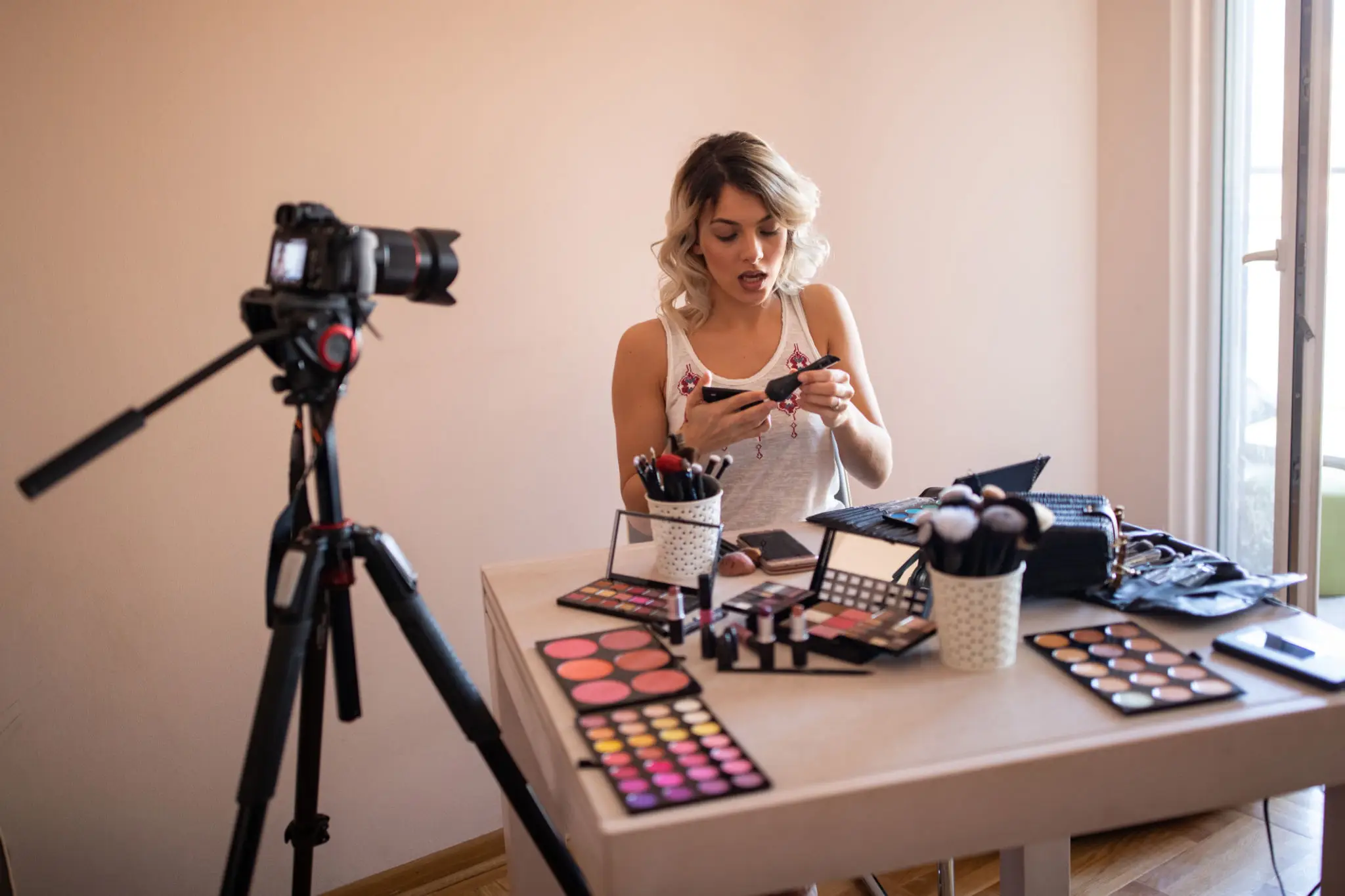Woman applying makeup on camera
