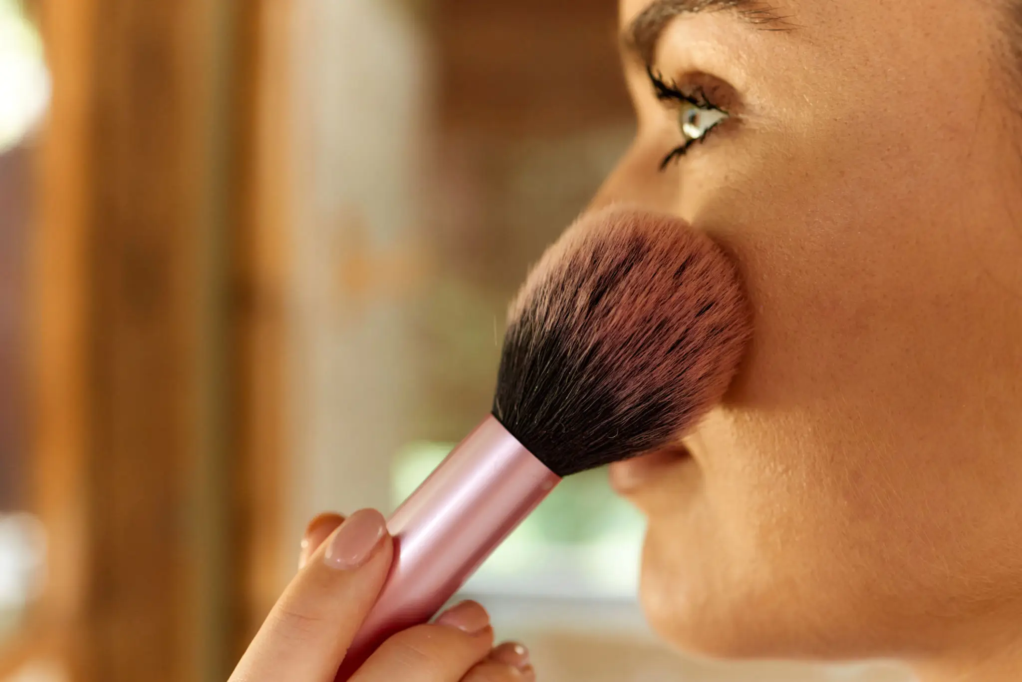 Woman using blush brush on face