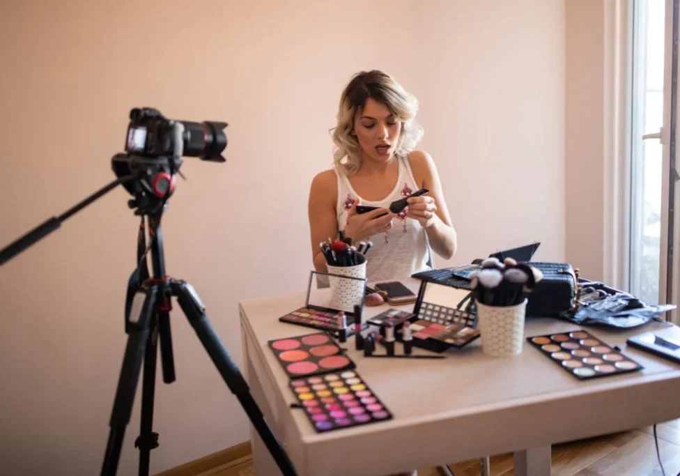 Woman applying makeup on camera